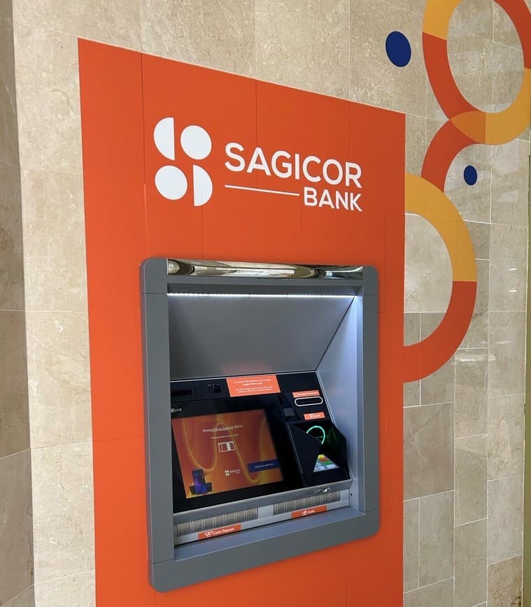 A Sagicor Bank Smart ABM set into an orange branded wall surround