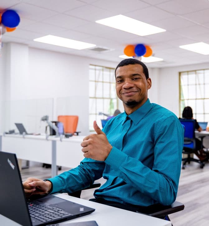 A Sagicor Bank team member working at a laptop in the office
